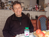 Natural Pharmaceuticals Hepactum™ FORTE Mosolygó idős nő világos háttér előtt, természetes megjelenéssel és világos hajjal.